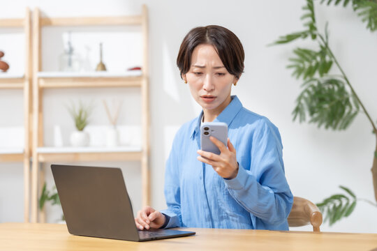 スマホを見て悩む女性