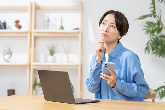 スマホを見て悩む女性
