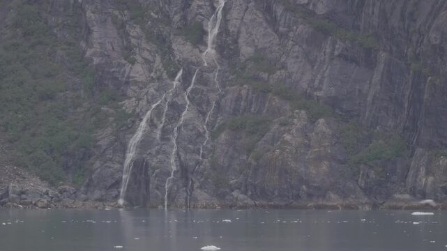 a view of a waterfall on the shore of tarr inlet from a cruise boat at glacier bay, alaska of the usa