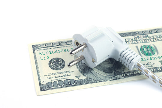 White power plug on US dollar banknotes over white background. Electricity bill, energy costs, global power expense and inflation concept.
