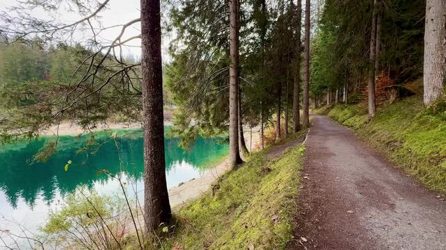Autumn scenery at Lake Cauma in Flims, Switzerland, with its small island reflected in calm, mirror-like water beneath a cloudy sky, symbolizing tranquility, mindfulness and natural beauty.
