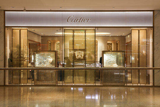The luxurious golden storefront and jewelry window display of a Cartier boutique inside Deji Plaza shopping mall in Nanjing, China.
