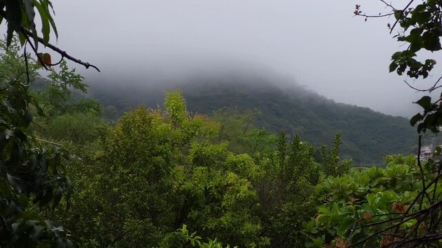 Mist Covered Mountain Peak Under Cloud Covered Sky