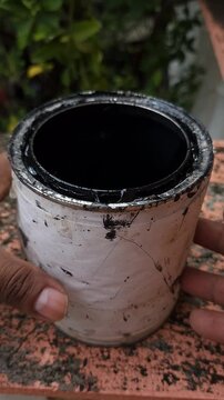 Opening Metal Can of Black Paint in Workshop