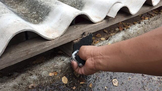 Hand Treating Roof Wooden Beams with Paint Soaked Rag