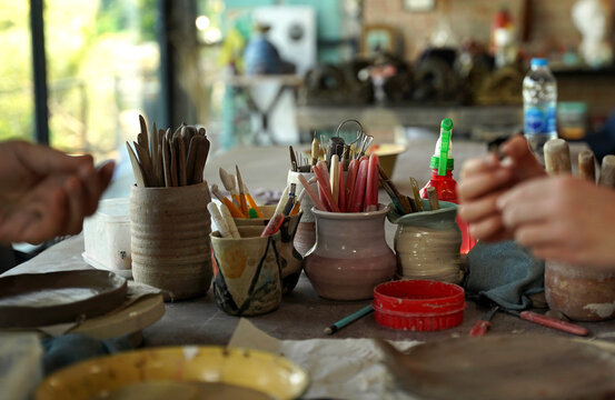 Children shaping clay plates in creative studio during ceramics workshop