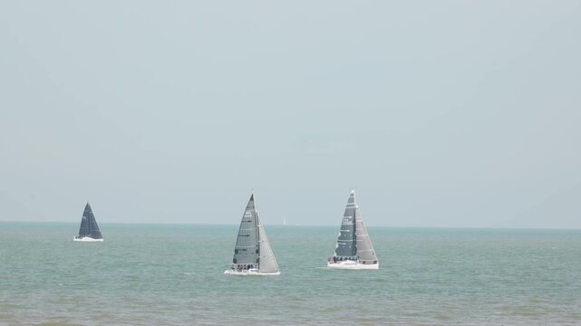 Sailing yachts with gray sails on the open sea world trip