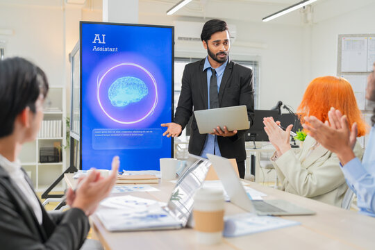 Diverse business team discussing artificial intelligence assistant presentation on digital screen in modern office, exploring AI technology for innovation