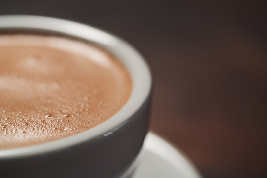 closeup of hot cocoa drink on walnut wood table