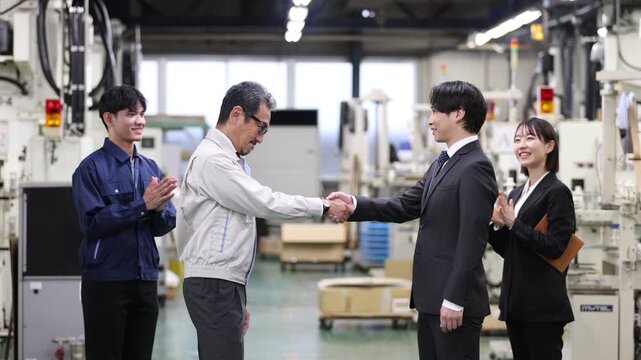 工場内で銀行担当者と握手を交わす製造業の経営者・企業融資契約の成立と資金調達