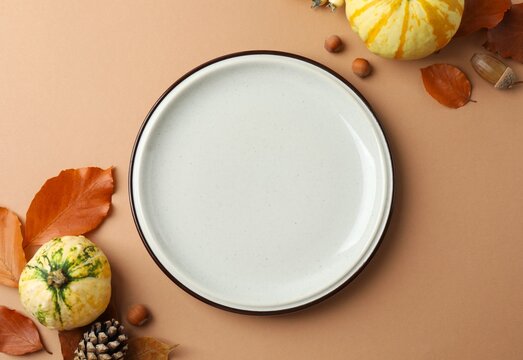 Top view of plate, autumn pumpkins and leaves. The concept of Halloween, Thanksgiving and other autumn holidays