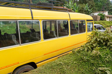 Yellow school bus parked in a rural village on the slopes of Mount Meru, Tanzania © Josh