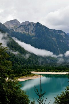 Turquoise Lake Predil Below Rugged Peaks and Low Clouds
