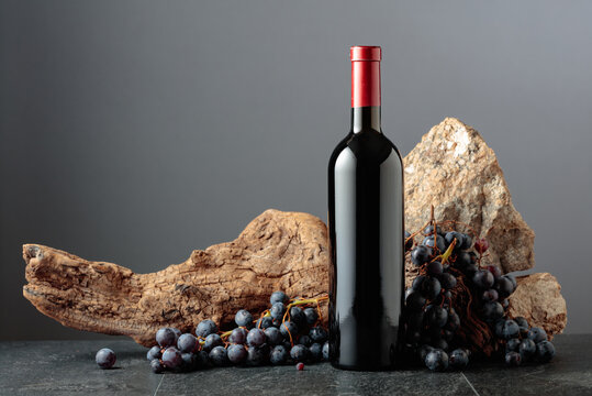 Bottle of red wine on a grey background.