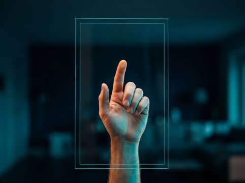 A hand poised to touch a transparent screen in a dimly lit, modern setting.