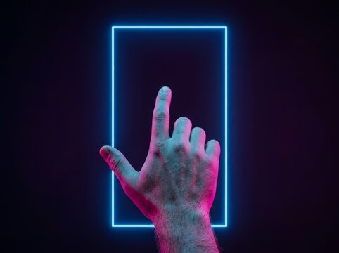 A hand illuminated by neon light extends towards a glowing rectangle in a dim room.