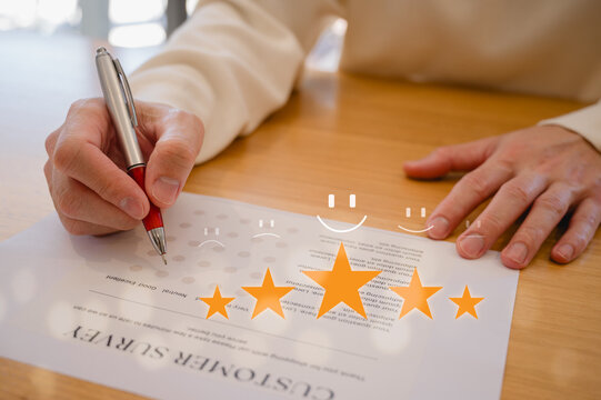 Customer service survey feedback and satisfaction concept, Businessman or client using pen give a feedback survey on paper form with stars and tick marks icons.