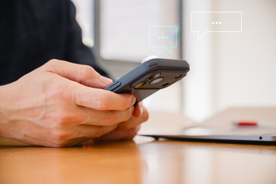 Social media marketing concept. Businessman hand using smartphone typing, chatting conversation in chat box icons pop up