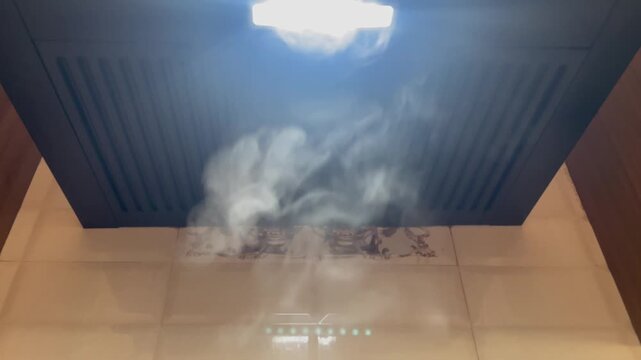 smoke rising from a ceiling exhaust vent under a chimney, illuminated by bright LED lighting, creates a high-contrast visual display