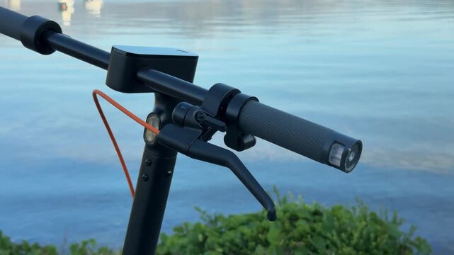 Electric Scooter Handlebar and Brake Lever beside Water