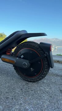 Electric Scooter Rear Wheel Revealed beside Blue Water