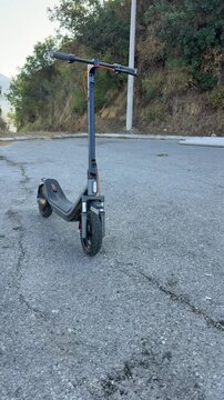 Front View of a Parked Electric Scooter on Cracked Pavement
