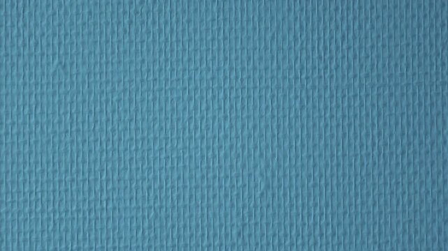 Teal painted wall with fine and coarse canvas-like woven textures in soft light, abstract backdrop, French Riviera, France.