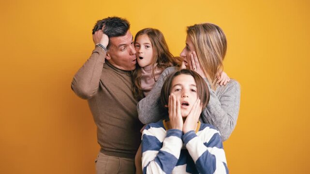 Caucasian family with two children expressing exaggerated shock and fear. Mother, father, son, and daughter looking at the camera with wide eyes