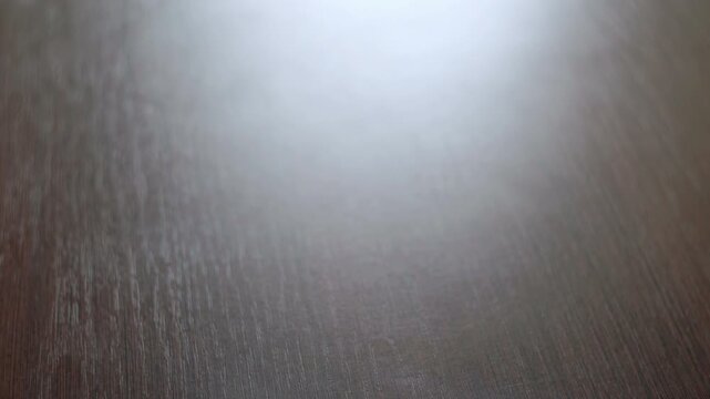 Glass granulated sugar dark table close up. Hand lifts sweet baking ingredient.