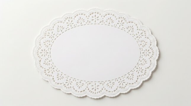 White oval paper doily with intricate lace pattern on plain light