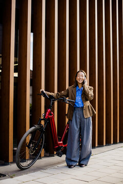 Korean woman enjoying a sunny day with her electric bike in the city