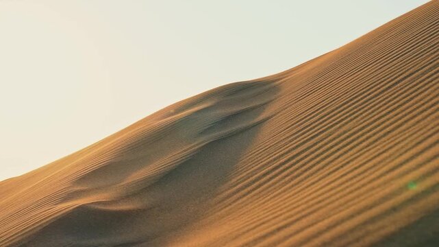 Aerial drone view of desert sand dunes, revealing flowing patterns and the natural beauty of the vast sandy landscape.