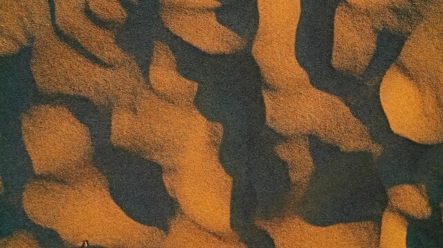 Slow motion of wind scattering sand grains across the dunes.