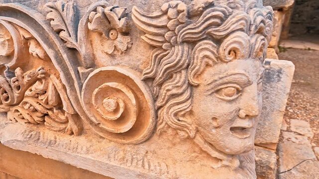 Myra Ancient City in Demre, Antalya, reveals intricate stone face carvings and ancient ruins in a detailed close up.