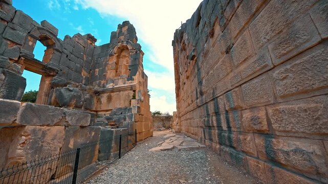 Myra Ancient City in Demre, Antalya, reveals the timeless beauty of ancient stone ruins as a visitor walks among the remnants of history.