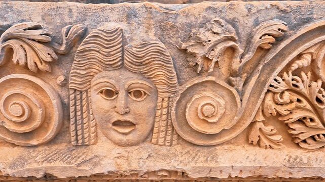 Myra Ancient City in Demre, Antalya, reveals intricate stone face carvings and ancient ruins in a detailed close up.