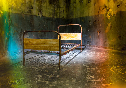 Altes, rostiges Metallbett mit einem geflochtenem Federkern und h&ouml;lzernen Kopfteil, das in einem verfallenen Raum steht, Berlin, Deutschland
