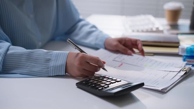Professional calculating figures on a desktop calculator beside printed financial reports, representing expense tracking, bookkeeping, accounting analysis, and business budget management.