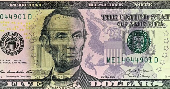 Five Dollar Bill Lincoln Portrait Under Scanning Light. Five dollar bill security light scans across Lincoln portrait shifting colors over engraved currency details. 