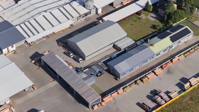 Aerial view of a modern sawmill plant with stacks of timber and warehouses