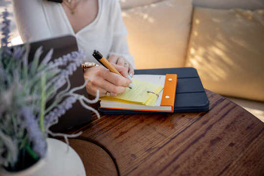 Businesswoman write in notebook at seaside cafe