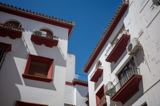 Whitewashed buildings with red balconies in Seville, Spain