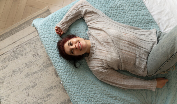 Woman relaxes on bed at home in the morning