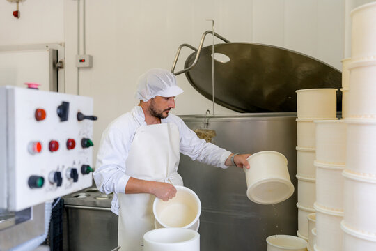 Cheesemaker prepare container for artisanal cheese production