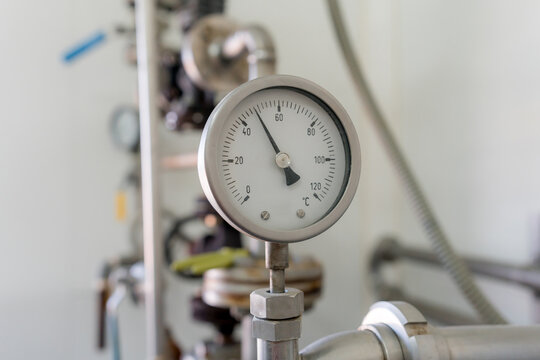 Analog temperature gauge on dairy pasteurizer equipment