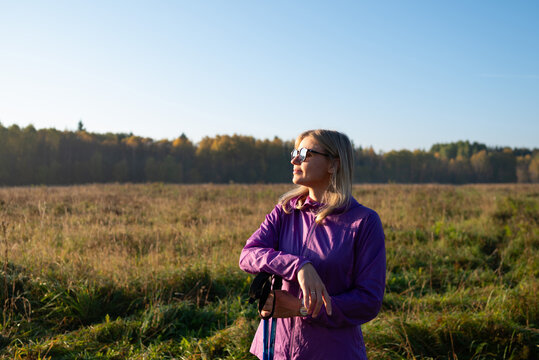 Woman in purple jacket enjoying autumn meadow outdoors
