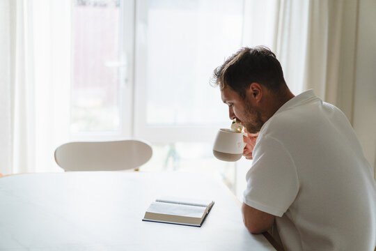 Man read Bible and drink tea at home