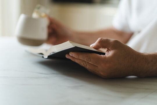 Person read Bible and drink tea at home