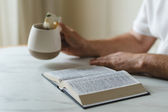 Man read Bible and drink tea at home