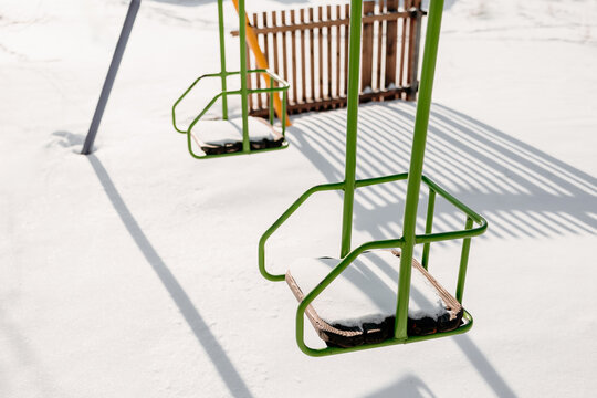 Green chair rows covered with snow in winter sunlight